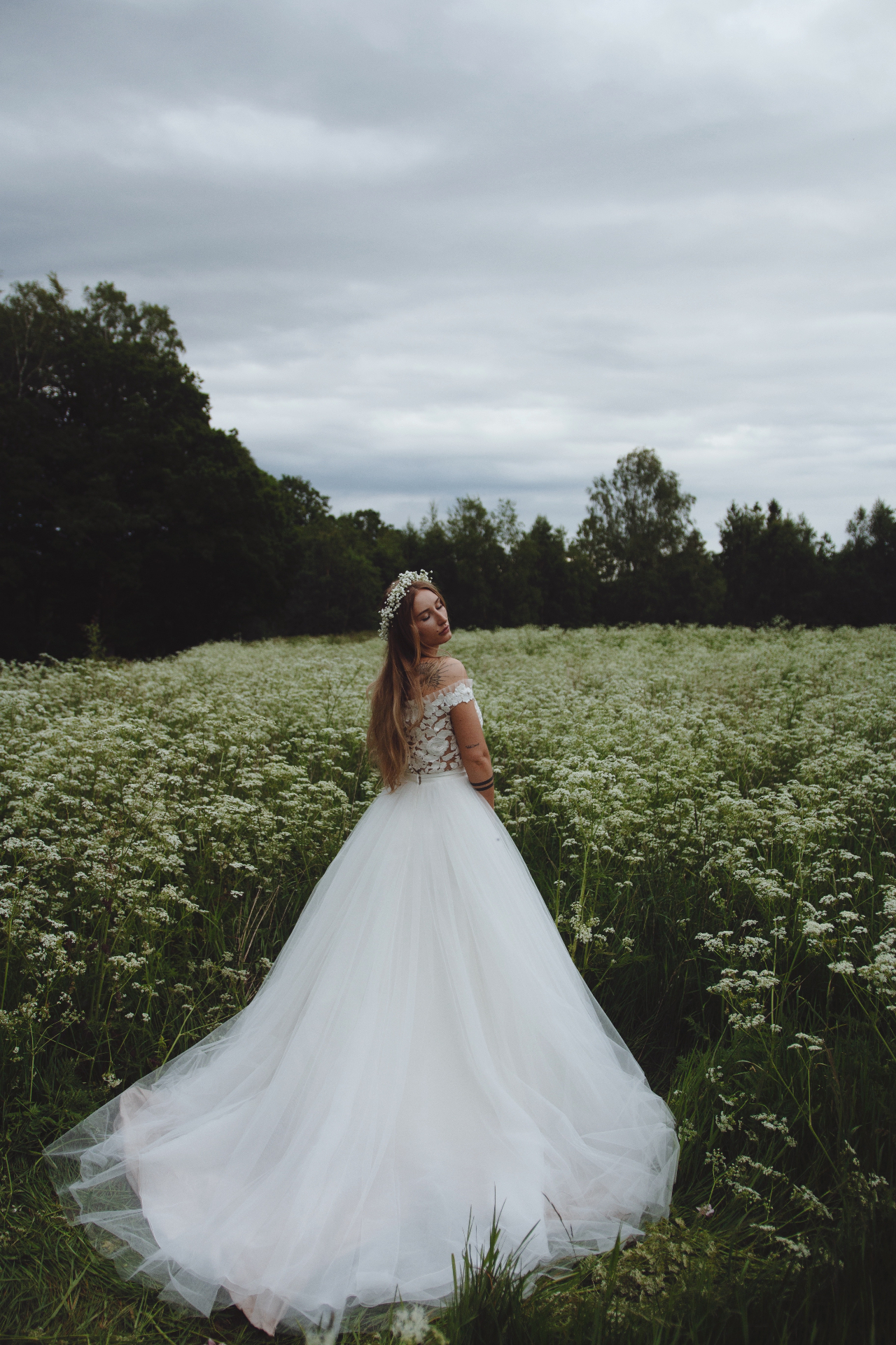 Brud i tyllklänning i blommande äng
